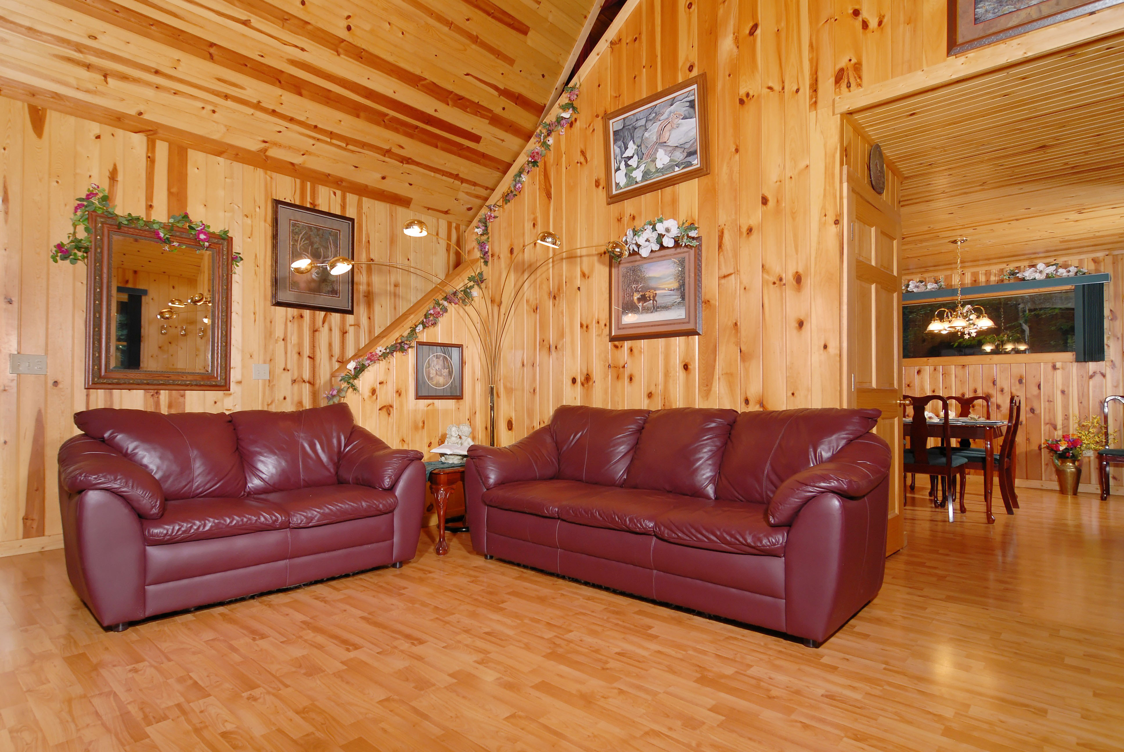 Leather couches that has stairs leading to the upstairs loft gameroom area.